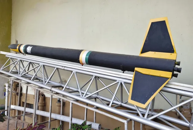 Detailed model rocket displayed on a metal launch stand at a planetarium